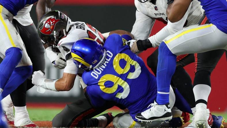 Nov 6, 2022; Tampa, Florida, USA;  Tampa Bay Buccaneers quarterback Tom Brady (12) is sacked by Los Angeles Rams defensive tackle Aaron Donald (99) in the third quarter at Raymond James Stadium. Mandatory Credit: Nathan Ray Seebeck-USA TODAY Sports