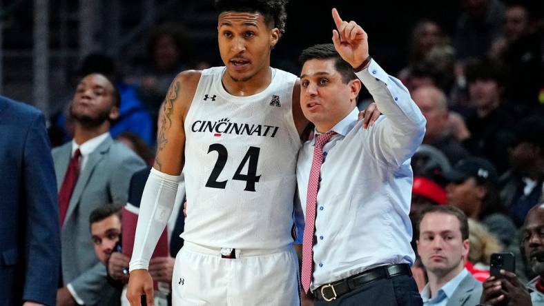 Cincinnati Bearcats guard Jeremiah Davenport (24) takes notes from head coach Wes Miller in the first half of the NCAA basketball game between the Cincinnati Bearcats and the Eastern Kentucky Colonels at Fifth Third Arena in Cincinnati on Sunday, Nov. 13, 2022.

Eastern Kentucky Colonels At Cincinnati Bearcats Basketball