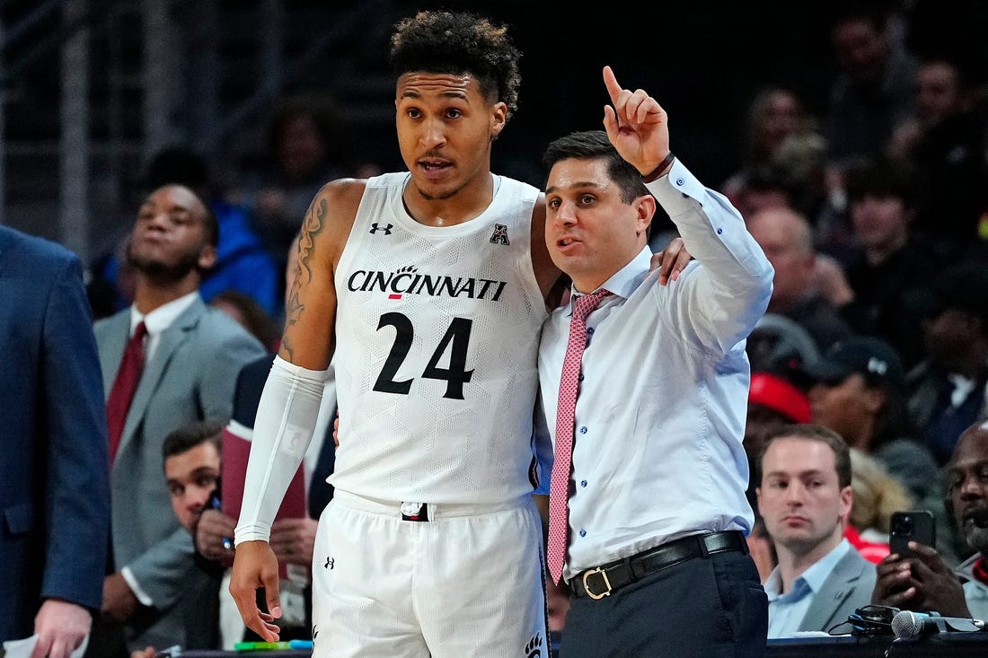 Cincinnati Bearcats guard Jeremiah Davenport (24) takes notes from head coach Wes Miller in the first half of the NCAA basketball game between the Cincinnati Bearcats and the Eastern Kentucky Colonels at Fifth Third Arena in Cincinnati on Sunday, Nov. 13, 2022.

Eastern Kentucky Colonels At Cincinnati Bearcats Basketball