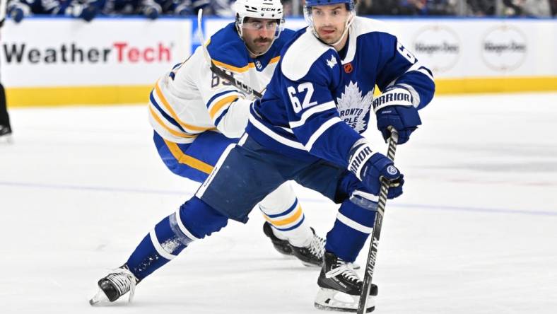 Nov 19, 2022; Toronto, Ontario, CAN;   Toronto Maple Leafs forward Denis Malgin (62) skates the puck away from Buffalo Sabres forward Alex Tuch (89) in the first period at Scotiabank Arena. Mandatory Credit: Dan Hamilton-USA TODAY Sports