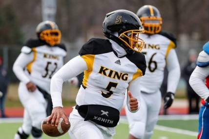 Detroit King quarterback Dante Moore (5) runs against Mason during the second half of Division 3 state semifinal at John Glenn High School in Westland on Saturday, Nov. 19, 2022.
