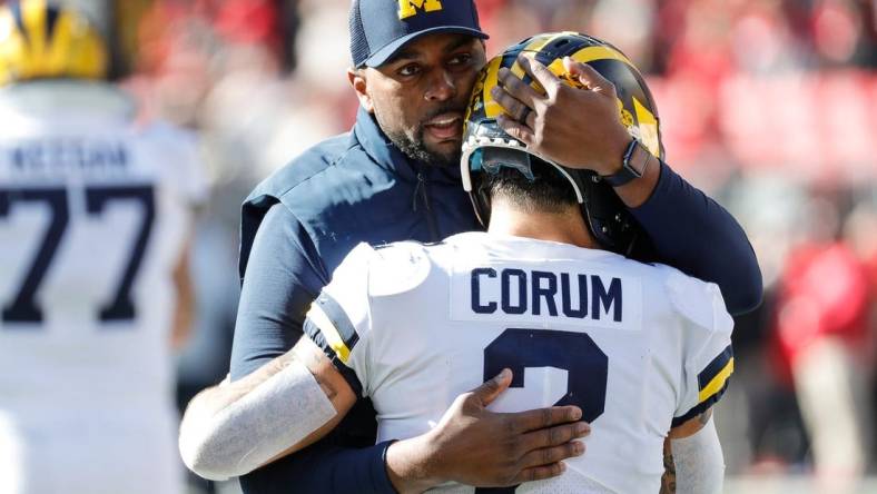 Michigan running back Blake Corum (2) is hugged by co-offensive coordinator Sherrone Moore during warmups before the game Nov. 26, 2022 against Ohio State at Ohio Stadium in Columbus.