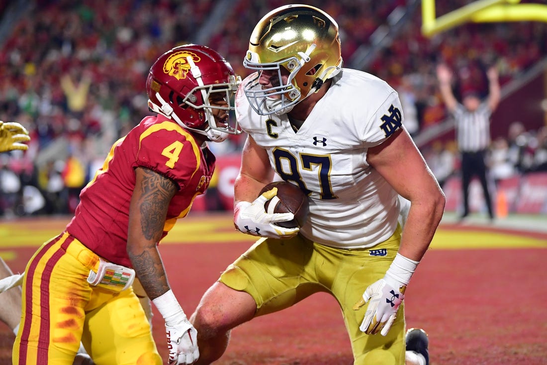 Nov 26, 2022; Los Angeles, California, USA; Notre Dame Fighting Irish tight end Michael Mayer (87) scores a touchdown against Southern California Trojans defensive back Max Williams (4) during the first half at the Los Angeles Memorial Coliseum. Mandatory Credit: Gary A. Vasquez-USA TODAY Sports