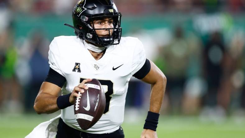 Nov 26, 2022; Tampa, Florida, USA; UCF Knights quarterback Mikey Keene (13) scrambles with the ball against the South Florida Bulls during the fourth quarter at Raymond James Stadium. Mandatory Credit: Douglas DeFelice-USA TODAY Sports