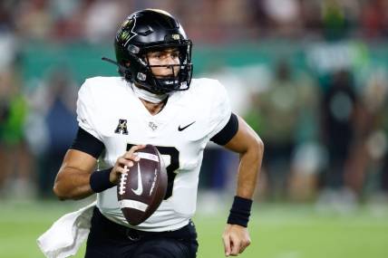 Nov 26, 2022; Tampa, Florida, USA; UCF Knights quarterback Mikey Keene (13) scrambles with the ball against the South Florida Bulls during the fourth quarter at Raymond James Stadium. Mandatory Credit: Douglas DeFelice-USA TODAY Sports
