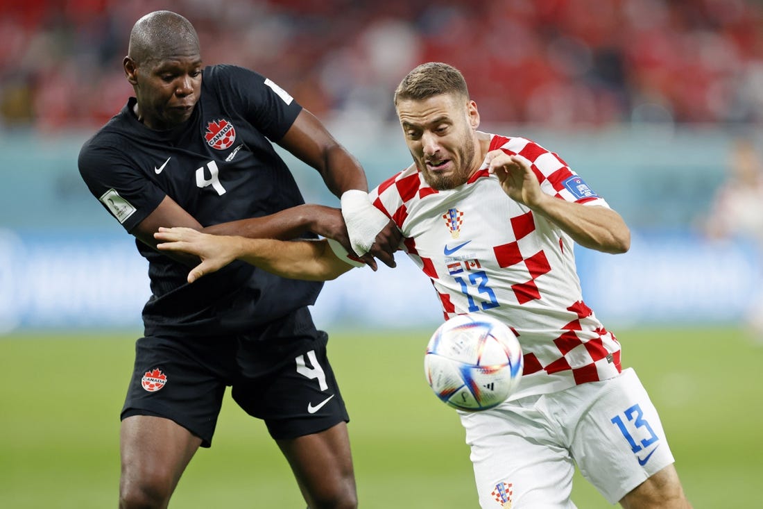 Nov 27, 2022; Doha, Qatar; Canada defender Kamal Miller (4) battles for the ball against Croatia midfielder Nikola Vlasic (13) during the second half of a group stage match during the 2022 World Cup at Khalifa International Stadium. Mandatory Credit: Yukihito Taguchi-USA TODAY Sports