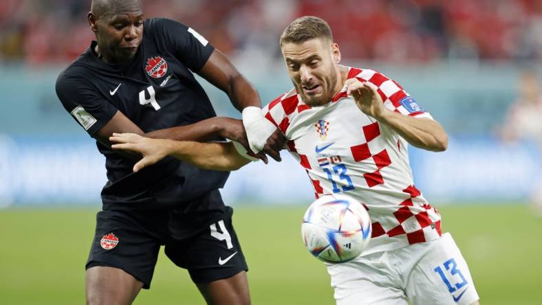 Nov 27, 2022; Doha, Qatar; Canada defender Kamal Miller (4) battles for the ball against Croatia midfielder Nikola Vlasic (13) during the second half of a group stage match during the 2022 World Cup at Khalifa International Stadium. Mandatory Credit: Yukihito Taguchi-USA TODAY Sports