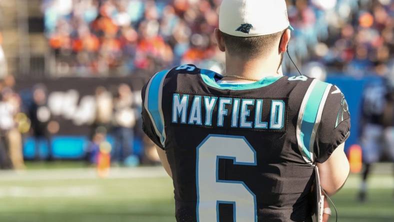 Nov 27, 2022; Charlotte, North Carolina, USA; Carolina Panthers quarterback Baker Mayfield (6) watches from the sidelines during the second quarter against the Denver Broncos at Bank of America Stadium. Mandatory Credit: Jim Dedmon-USA TODAY Sports