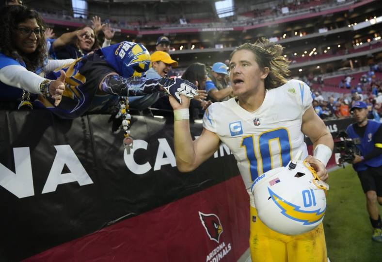 Nov 27, 2022; Glendale, AZ, USA;  Los Angeles Chargers quarterback Justin Herbert (10) celebrates with fans after winning 25-24 against the Arizona Cardinals at State Farm Stadium. Mandatory Credit: Michael Chow-USA TODAY Sports