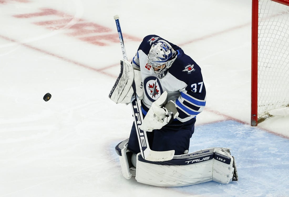 Nov 27, 2022; Chicago, Illinois, USA; Winnipeg Jets goaltender Connor Hellebuyck (37) defends a shot by the Chicago Blackhawks during the second period at United Center. Mandatory Credit: Kamil Krzaczynski-USA TODAY Sports