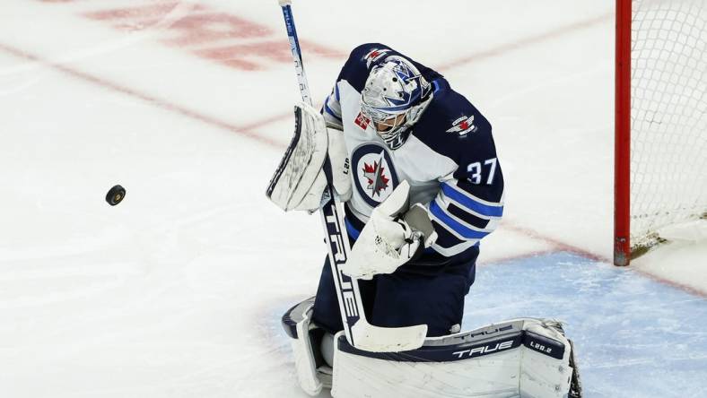 Nov 27, 2022; Chicago, Illinois, USA; Winnipeg Jets goaltender Connor Hellebuyck (37) defends a shot by the Chicago Blackhawks during the second period at United Center. Mandatory Credit: Kamil Krzaczynski-USA TODAY Sports