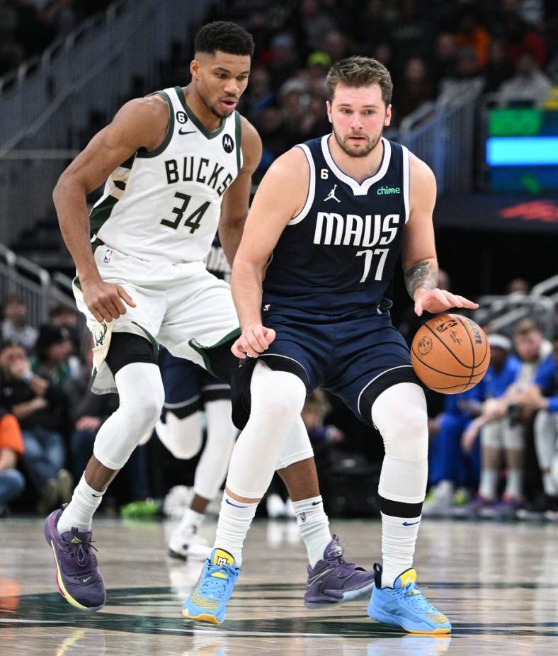 Dallas Mavericks guard Luka Doncic (77) dribbles the ball up court against Milwaukee Bucks forward Giannis Antetokounmpo (34) in the second half at Fiserv Forum. Mandatory Credit: Michael McLoone-USA TODAY Sports