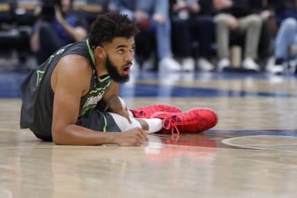 Nov 28, 2022; Washington, District of Columbia, USA; Minnesota Timberwolves center Karl-Anthony Towns (32) holds his leg after being injured against the Washington Wizards in the third quarter at Capital One Arena. Mandatory Credit: Geoff Burke-USA TODAY Sports