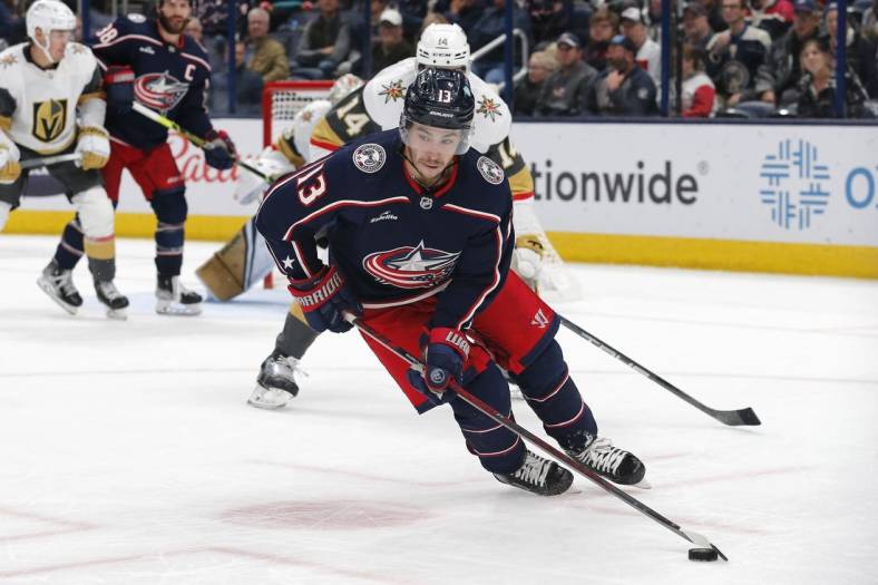 Nov 28, 2022; Columbus, Ohio, USA; Columbus Blue Jackets left wing Johnny Gaudreau (13) carries the puck away from Vegas Golden Knights defenseman Nicolas Hague (14) during the third period at Nationwide Arena. Mandatory Credit: Russell LaBounty-USA TODAY Sports