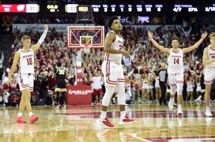 Nov 29, 2022; Madison, Wisconsin, USA;  Wisconsin Badgers guard Chucky Hepburn (23) looks on as teammates Isaac Lindsey (10) and Carter Gilmore (14) celebrate his buzzer-beating shot at the end of the first half at the Kohl Center. Mandatory Credit: Kayla Wolf-USA TODAY Sports