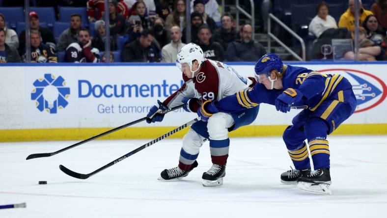 Dec 1, 2022; Buffalo, New York, USA;  Colorado Avalanche center Nathan MacKinnon (29) skates with the puck as Buffalo Sabres defenseman Rasmus Dahlin (26) defends during the first period at KeyBank Center. Mandatory Credit: Timothy T. Ludwig-USA TODAY Sports