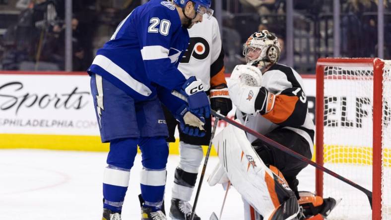 Dec 1, 2022; Philadelphia, Pennsylvania, USA; Tampa Bay Lightning left wing Nicholas Paul (20) pulls the puck from his goal to give to center Steven Stamkos (91) after recording his 1000 career point during the second period against the Philadelphia Flyers at Wells Fargo Center. Mandatory Credit: Bill Streicher-USA TODAY Sports