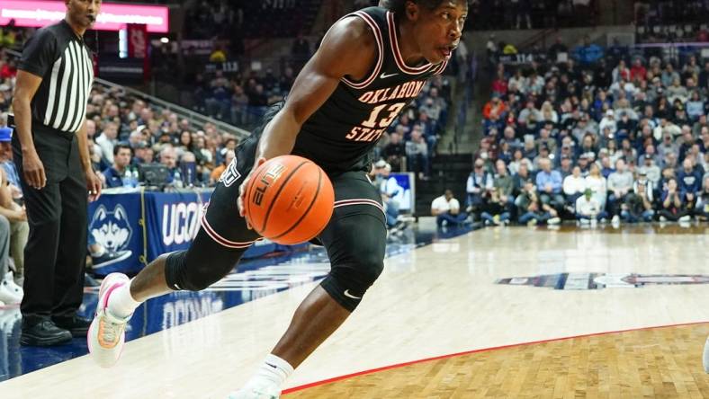 Dec 1, 2022; Storrs, Connecticut, USA; Oklahoma State Cowboys guard Quinn Williams (13) dribbles the ball toward the basket against the Connecticut Huskies during the second half at Harry A. Gampel Pavilion. Mandatory Credit: Gregory Fisher-USA TODAY Sports