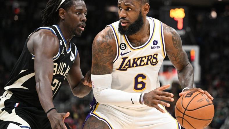 Dec 2, 2022; Milwaukee, Wisconsin, USA; Los Angeles Lakers forward LeBron James (6) posts up against Milwaukee Bucks guard Jrue Holiday (21) in the second quarter at Fiserv Forum. Mandatory Credit: Michael McLoone-USA TODAY Sports