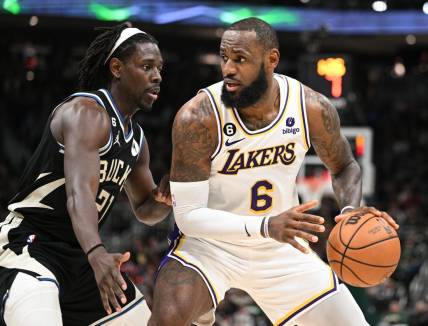 Dec 2, 2022; Milwaukee, Wisconsin, USA; Los Angeles Lakers forward LeBron James (6) posts up against Milwaukee Bucks guard Jrue Holiday (21) in the second quarter at Fiserv Forum. Mandatory Credit: Michael McLoone-USA TODAY Sports