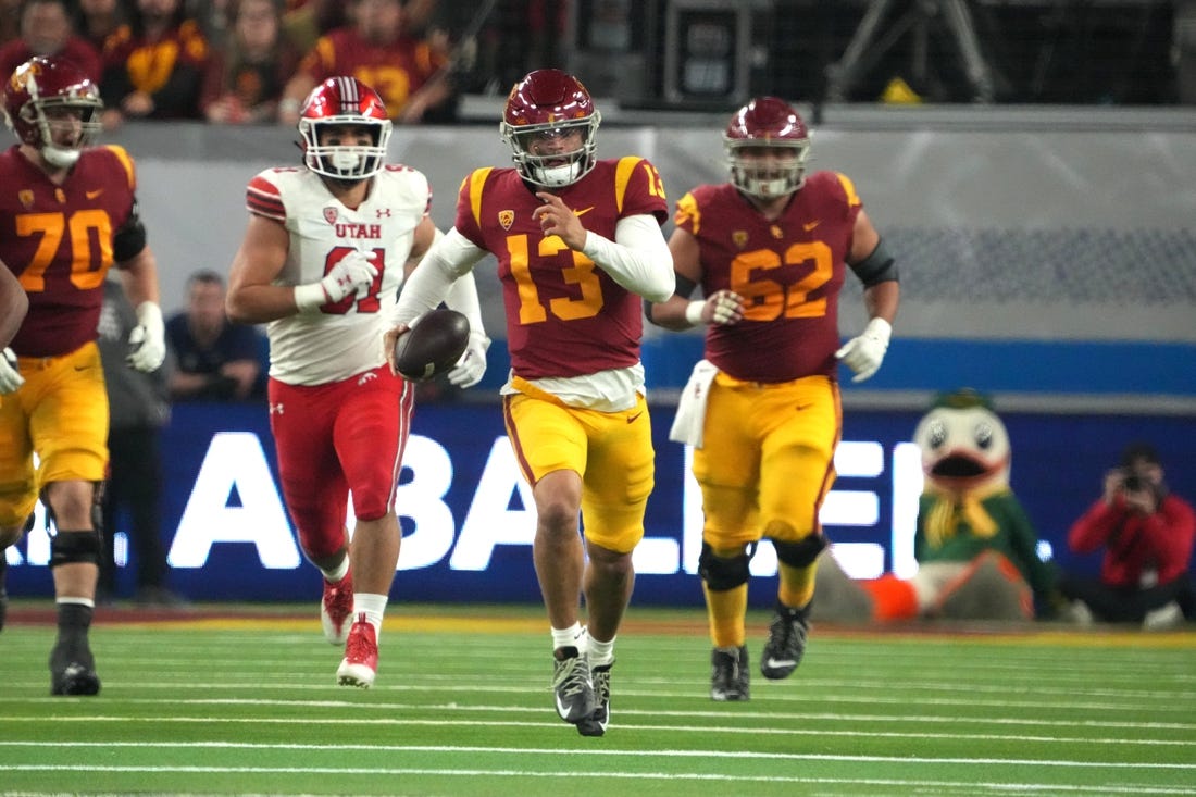 Dec 2, 2022; Las Vegas, NV, USA; Southern California Trojans quarterback Caleb Williams (13) carries the ball against the Utah Utes in the second half of the Pac-12 Championship at Allegiant Stadium. Mandatory Credit: Kirby Lee-USA TODAY Sports