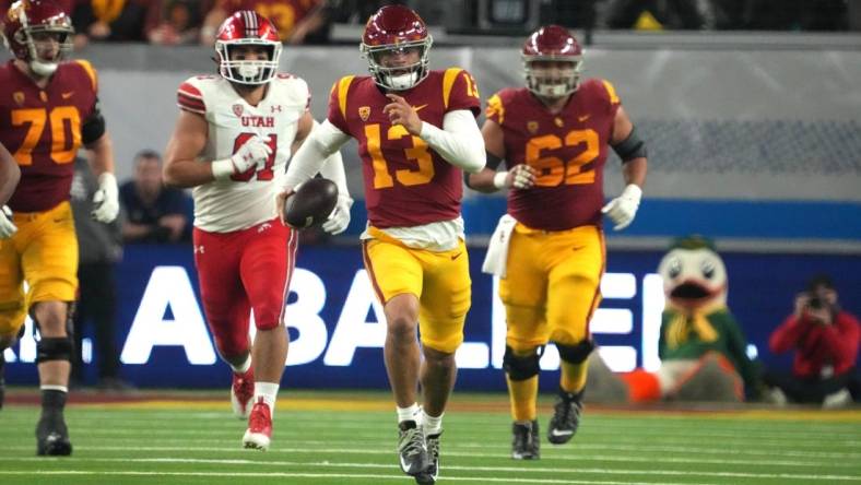 Dec 2, 2022; Las Vegas, NV, USA; Southern California Trojans quarterback Caleb Williams (13) carries the ball against the Utah Utes in the second half of the Pac-12 Championship at Allegiant Stadium. Mandatory Credit: Kirby Lee-USA TODAY Sports