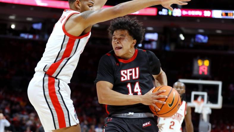 Dec 3, 2022; Columbus, Ohio, USA;  St. Francis (Pa) Red Flash guard Landon Moore (14) is guarded closely by Ohio State Buckeyes guard Roddy Gayle Jr. (1) during the first half at Value City Arena. Mandatory Credit: Joseph Maiorana-USA TODAY Sports