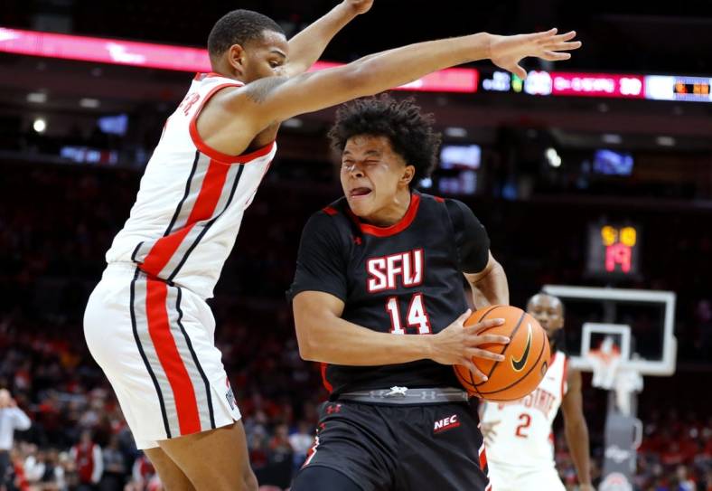 Dec 3, 2022; Columbus, Ohio, USA;  St. Francis (Pa) Red Flash guard Landon Moore (14) is guarded closely by Ohio State Buckeyes guard Roddy Gayle Jr. (1) during the first half at Value City Arena. Mandatory Credit: Joseph Maiorana-USA TODAY Sports