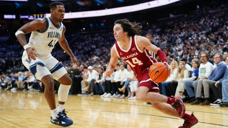 Dec 3, 2022; Philadelphia, Pennsylvania, USA; Oklahoma Sooners guard Bijan Cortes (14) dribbles the ball against Villanova Wildcats forward Eric Dixon (43) during the first half at Wells Fargo Center. Mandatory Credit: Gregory Fisher-USA TODAY Sports