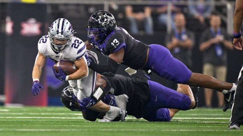 Dec 3, 2022; Arlington, TX, USA; Kansas State Wildcats running back Deuce Vaughn (22) is tackled by TCU Horned Frogs linebacker Dee Winters (13) during the second quarter at AT&T Stadium. Mandatory Credit: Jerome Miron-USA TODAY Sports