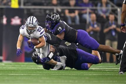 Dec 3, 2022; Arlington, TX, USA; Kansas State Wildcats running back Deuce Vaughn (22) is tackled by TCU Horned Frogs linebacker Dee Winters (13) during the second quarter at AT&T Stadium. Mandatory Credit: Jerome Miron-USA TODAY Sports