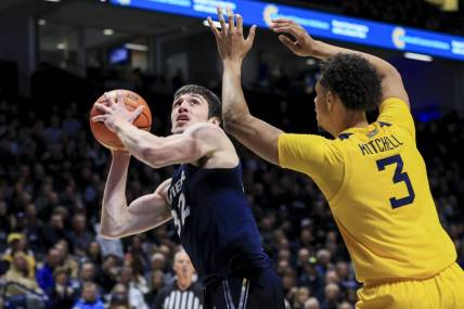Dec 3, 2022; Cincinnati, Ohio, USA;  Xavier Musketeers forward Zach Freemantle (32) drives to the basket against West Virginia Mountaineers forward Tre Mitchell (3) in the first half at Cintas Center. Mandatory Credit: Aaron Doster-USA TODAY Sports