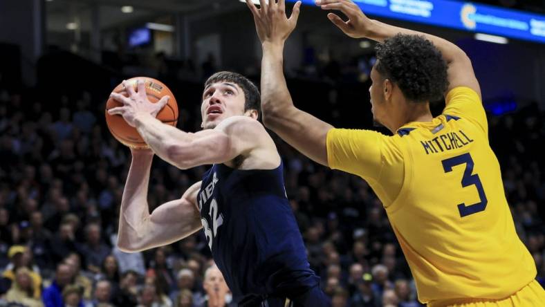 Dec 3, 2022; Cincinnati, Ohio, USA;  Xavier Musketeers forward Zach Freemantle (32) drives to the basket against West Virginia Mountaineers forward Tre Mitchell (3) in the first half at Cintas Center. Mandatory Credit: Aaron Doster-USA TODAY Sports