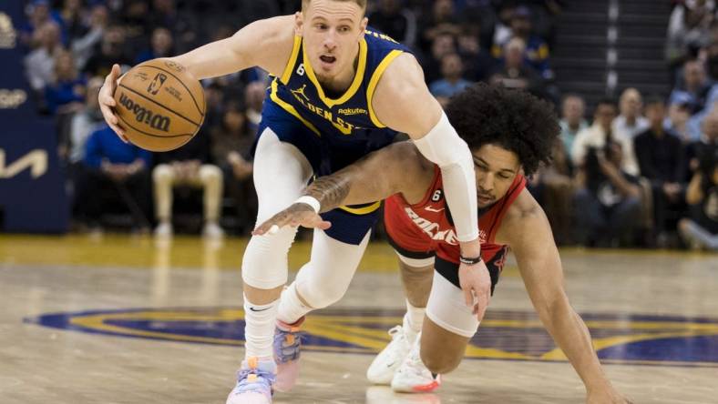 Dec 3, 2022; San Francisco, California, USA;  Golden State Warriors guard Donte DiVincenzo (0) gains possession of the ball against Houston Rockets guard Daishen Nix (15) during the first half at Chase Center. Mandatory Credit: John Hefti-USA TODAY Sports