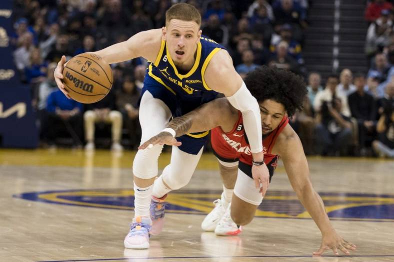 Dec 3, 2022; San Francisco, California, USA;  Golden State Warriors guard Donte DiVincenzo (0) gains possession of the ball against Houston Rockets guard Daishen Nix (15) during the first half at Chase Center. Mandatory Credit: John Hefti-USA TODAY Sports