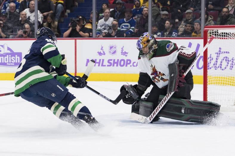 Dec 3, 2022; Vancouver, British Columbia, CAN; Arizona Coyotes goalie Karel Vejmelka (70) makes a save against Vancouver Canucks forward Sheldon Dries (15) in the first period at Rogers Arena. Mandatory Credit: Bob Frid-USA TODAY Sports