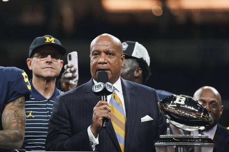 Dec 3, 2022; Indianapolis, Indiana, USA;  Big Ten Commissioner Kevin Warren presents the championship trophy to Michigan Wolverines head coach Jim Harbaugh following their 43-22 victory against Purdue in the Big Ten Championship at Lucas Oil Stadium. Mandatory Credit: Robert Goddin-USA TODAY Sports