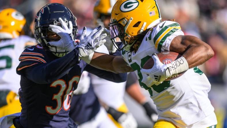 Dec 4, 2022; Chicago, Illinois, USA; Green Bay Packers running back Aaron Jones (33) runs the ball as Chicago Bears defensive back DeAndre Houston-Carson (36) pursues on defense in the first quarter at Soldier Field. Mandatory Credit: Daniel Bartel-USA TODAY Sports