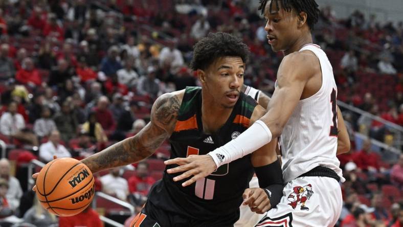 Dec 4, 2022; Louisville, Kentucky, USA;  Miami (Fl) Hurricanes guard Jordan Miller (11) dribbles against Louisville Cardinals forward JJ Traynor (12) during the first half at KFC Yum! Center. Mandatory Credit: Jamie Rhodes-USA TODAY Sports