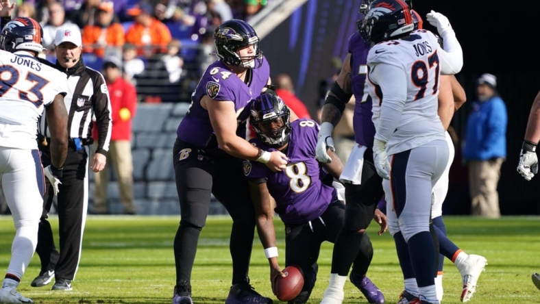 Dec 4, 2022; Baltimore, Maryland, USA; Baltimore Ravens quarterback Lamar Jackson (8) is helped to his feet by center Tyler Linderbaum (64) after being sacked by the Denver Broncos at M&T Bank Stadium. Mandatory Credit: Mitch Stringer-USA TODAY Sports