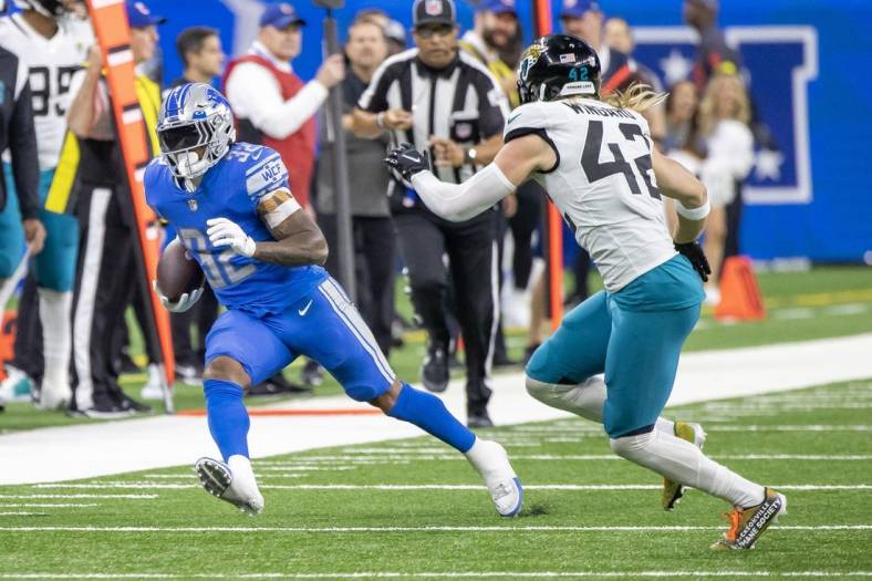 Dec 4, 2022; Detroit, Michigan, USA; Detroit Lions running back D'Andre Swift (32) runs with the ball and tries to avoid a tackle from Jacksonville Jaguars safety Andrew Wingard (42) during the first half at Ford Field. Mandatory Credit: David Reginek-USA TODAY Sports