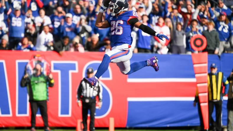 Dec 4, 2022; East Rutherford, New Jersey, USA; New York Giants running back Saquon Barkley (26) leaps into the end zone for a touchdown against the Washington Commanders during the first half at MetLife Stadium. Mandatory Credit: Rich Barnes-USA TODAY Sports