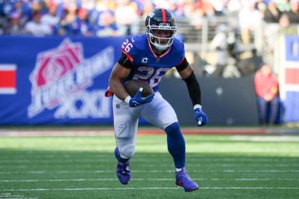 Dec 4, 2022; East Rutherford, New Jersey, USA; New York Giants running back Saquon Barkley (26) runs with the ball against the Washington Commanders during the first half at MetLife Stadium. Mandatory Credit: Rich Barnes-USA TODAY Sports