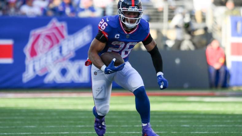 Dec 4, 2022; East Rutherford, New Jersey, USA; New York Giants running back Saquon Barkley (26) runs with the ball against the Washington Commanders during the first half at MetLife Stadium. Mandatory Credit: Rich Barnes-USA TODAY Sports