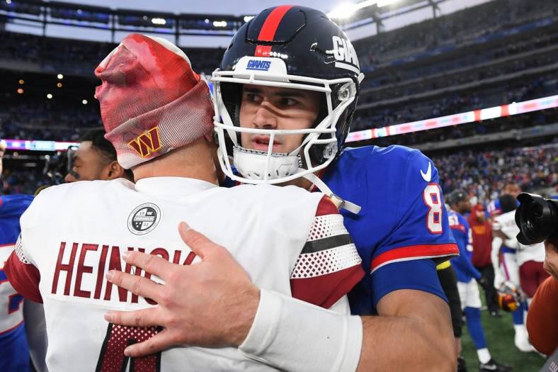 Dec 4, 2022; East Rutherford, New Jersey, USA; Washington Commanders quarterback Taylor Heinicke (left) and New York Giants quarterback Daniel Jones (right) embrace on the field following the game at MetLife Stadium. Mandatory Credit: Rich Barnes-USA TODAY Sports