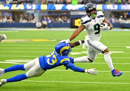Dec 4, 2022; Inglewood, California, USA; Seattle Seahawks running back Kenneth Walker III (9) runs past Los Angeles Rams safety Nick Scott (33) for a first down in the first half at SoFi Stadium. Mandatory Credit: Jayne Kamin-Oncea-USA TODAY Sports