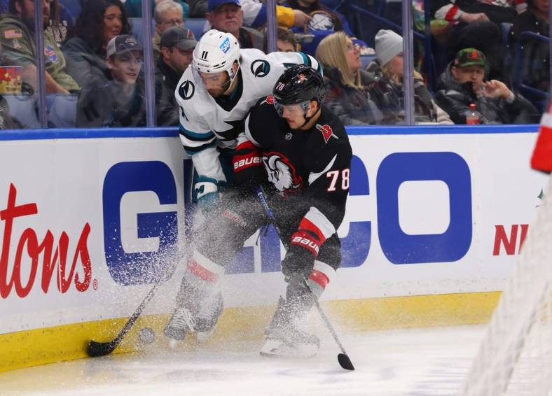 Dec 4, 2022; Buffalo, New York, USA;  Buffalo Sabres defenseman Jacob Bryson (78) checks San Jose Sharks center Luke Kunin (11) as they go after a loose puck behind the net during the first period at KeyBank Center. Mandatory Credit: Timothy T. Ludwig-USA TODAY Sports