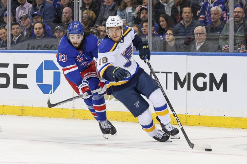 Dec 5, 2022; New York, New York, USA; St. Louis Blues center Robert Thomas (18) skates with the puck against New York Rangers center Mika Zibanejad (93) during the first period at Madison Square Garden. Mandatory Credit: Vincent Carchietta-USA TODAY Sports