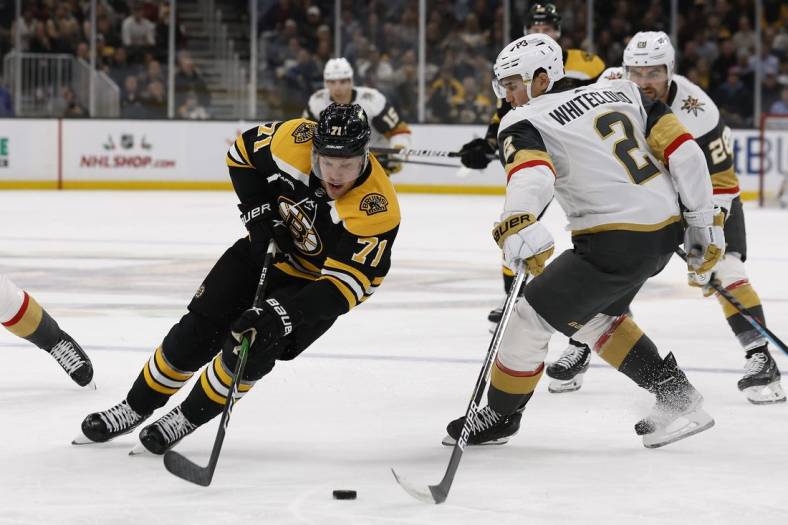 Dec 5, 2022; Boston, Massachusetts, USA; Boston Bruins left wing Taylor Hall (71) goes around Vegas Golden Knights defenseman Zach Whitecloud (2) during the first period at TD Garden. Mandatory Credit: Winslow Townson-USA TODAY Sports
