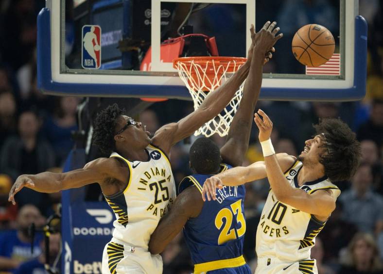 Dec 5, 2022; San Francisco, California, USA; Indiana Pacers forward Jalen Smith (25) and guard Kendall Brown (10) combine to block a shot by Golden State Warriors forward Draymond Green (23) during the first quarter at Chase Center. Mandatory Credit: D. Ross Cameron-USA TODAY Sports